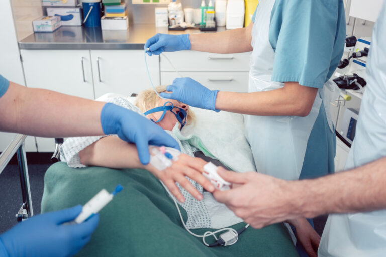 Médicos preparando paciente sedada para exame de sonoendoscopia