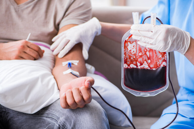 Pessoa fazendo exame de sangue, que pode detectar a anemia falciforme; ao lado, mão de médico segura bolsa de sangue